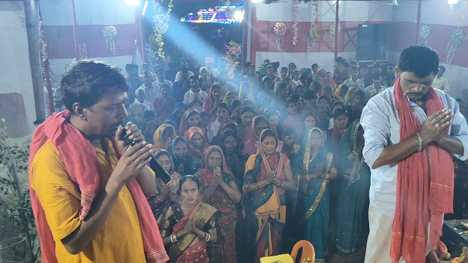 Night-time puja gathering with lights and devotees
